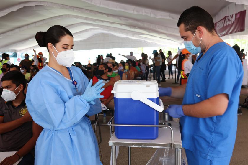Enfermera y enfermero preparando la dosis de vacunacion