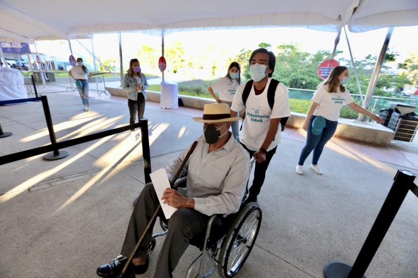 Un hombre en silla de ruedas espera su turno para ser vacunado